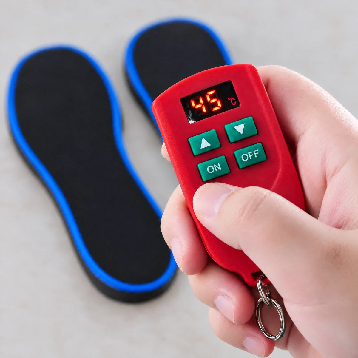 Red remote control with °C display and ▲, ▼, ON and OFF buttons held in a hand